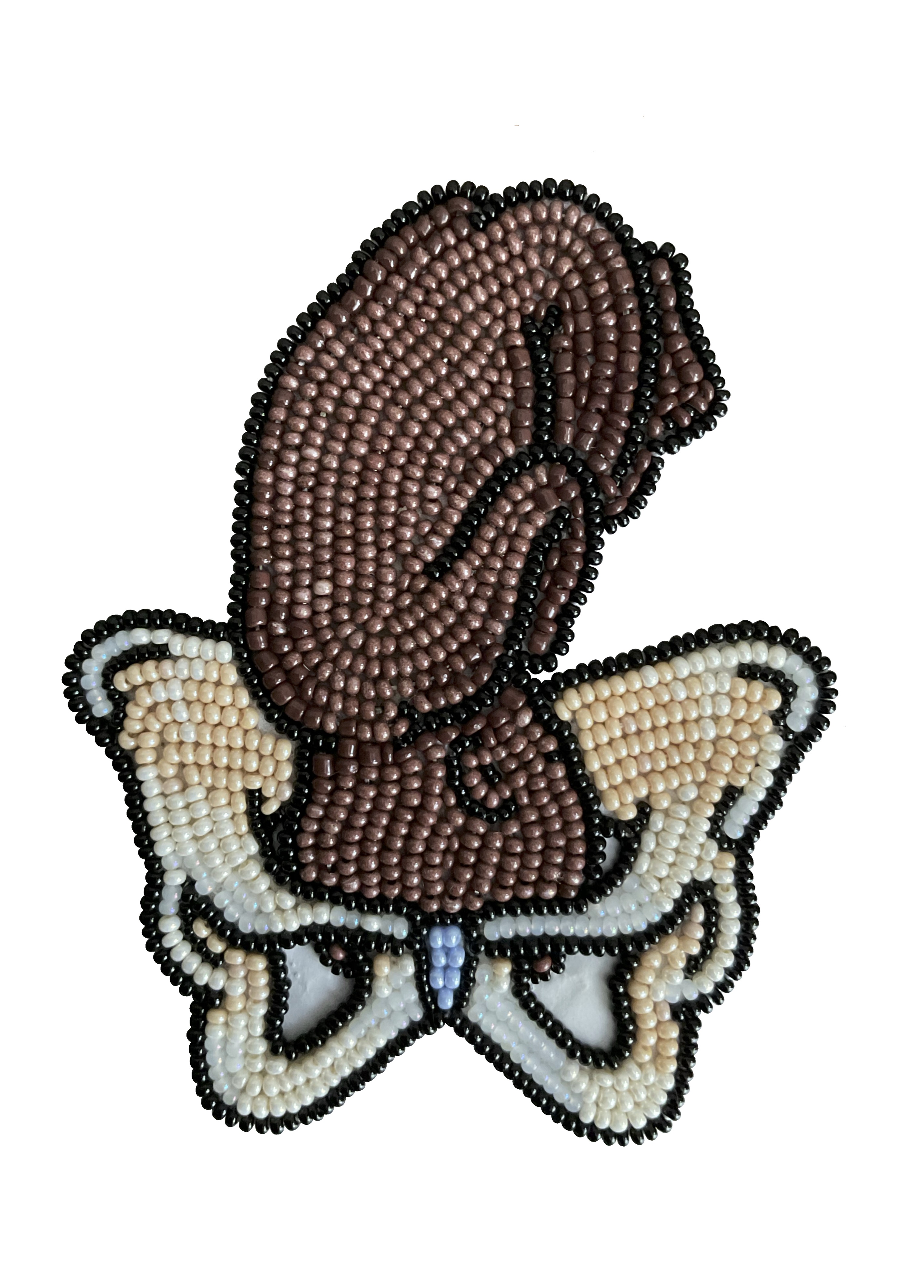 Handmade beadwork depicting a Black fetus with their head within a pelvic bone, about to be born.